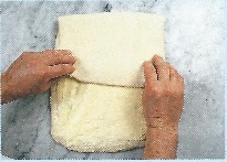 Picture of bread being enclosed with dough; baker folds top down so dough is divided into three portion - like a business letter