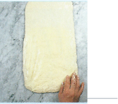 Picture of dough being rolled out into a long rectangle